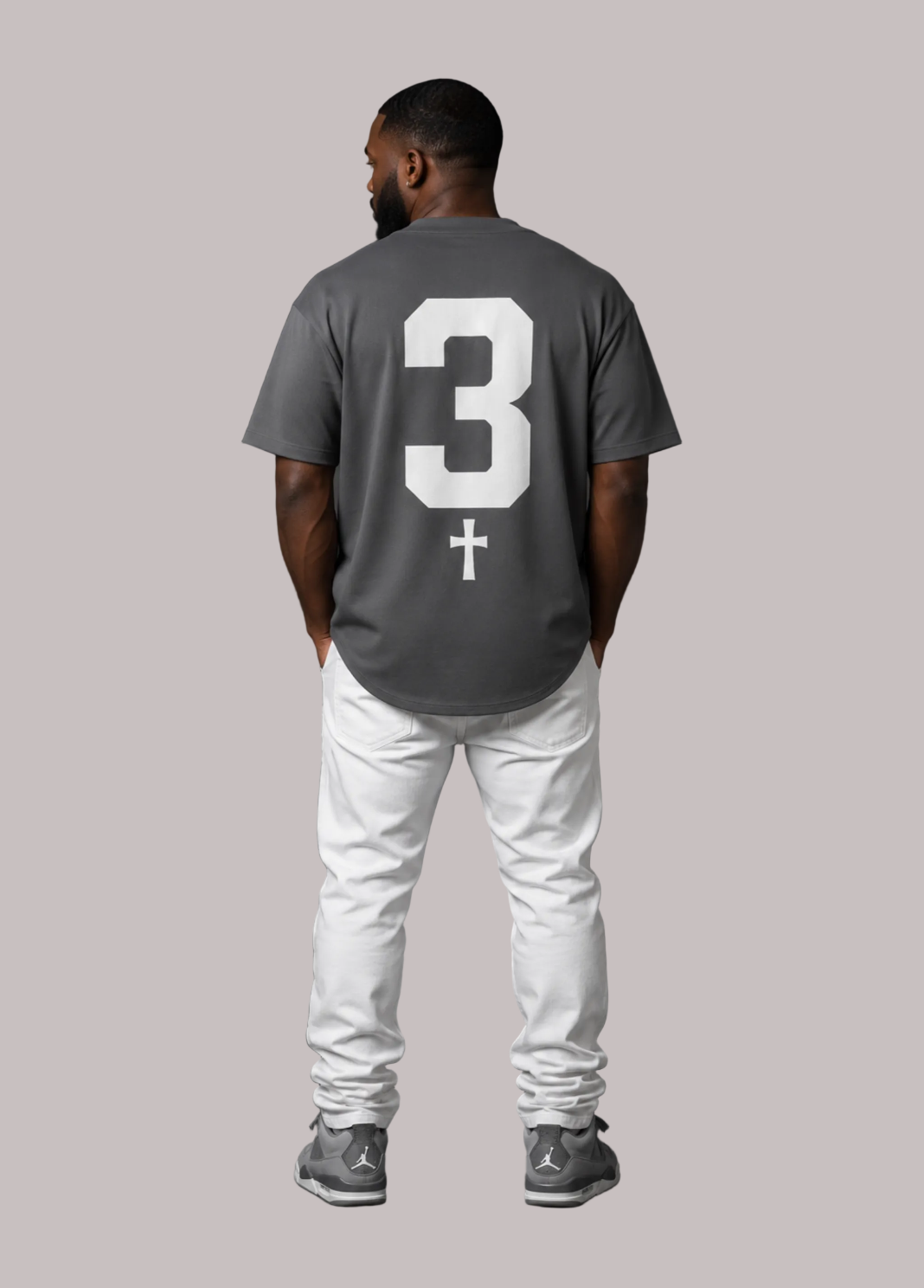 Man wearing a gray t-shirt with the number 3 on the back against a dark background
